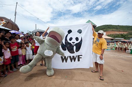 Waddy the mascot clowning around in Taytay Fiesta with WWF Flag held by Benjie & Stella