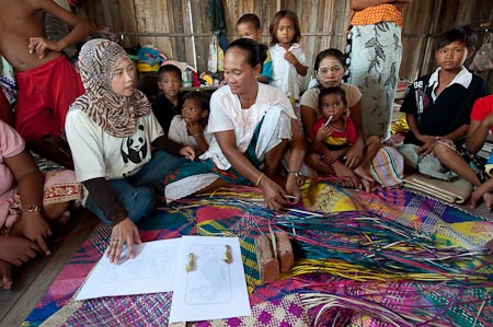 Myezana Ismat of WWF Malaysia suggesting alternative touristy designs to a Bajau weaver
