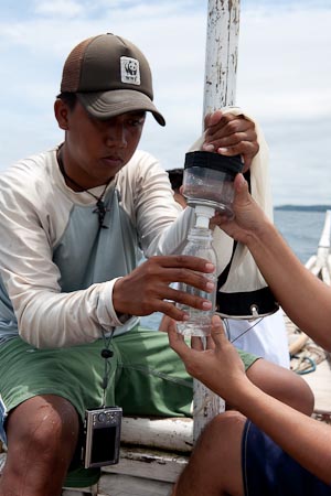 Jose Buella Jr. transfers plankton samples into a bottle