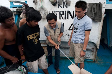 Rudy demonstrating the use of a de-hooker to a longline fisherman