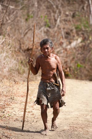 An old Manyan farmer walking two kilometers to the nearest town from their village