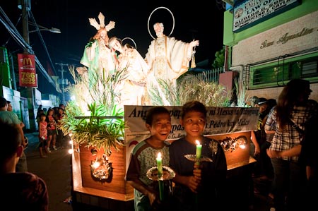 Two boys with their candles lit get ready to walk the town of Baliwag for the procession