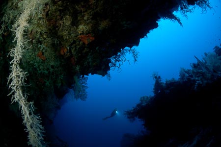 The deep 35 meter swim through at South Emma looking out to the clear waters of the Bismarck Sea