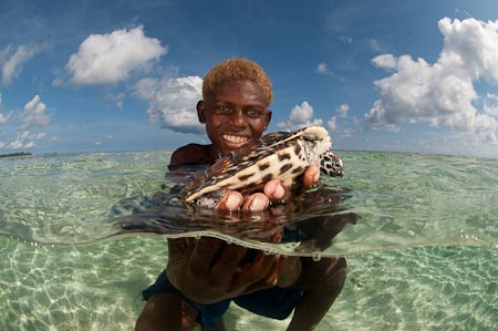 Young boy Lapan holds a pet green turtle