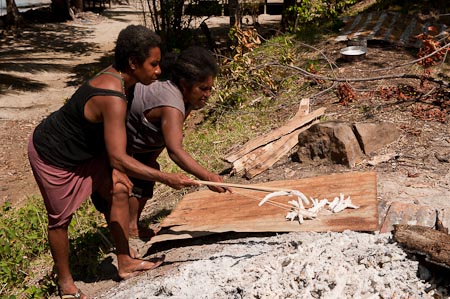 Talawan and Lomot pick out the burned corals. When cooled down, corals are stored in a leaf lined basket for two weeks to crumble 