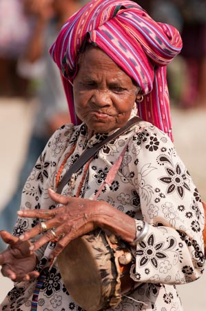 A woman plays her well pounded drum or babadok as they perform non-stop one Sunday afternoon in the streets of Comoro