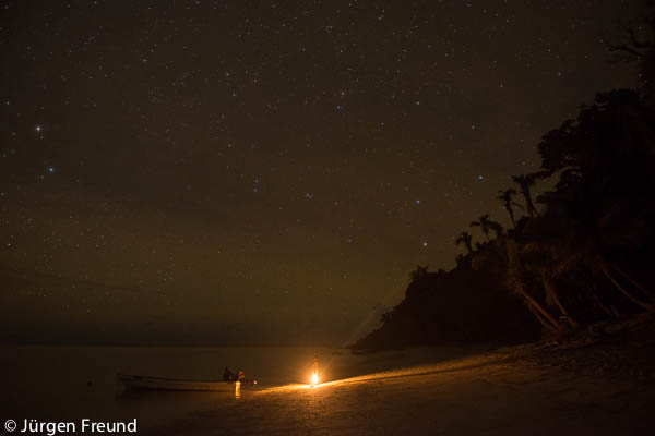 Night stars out as villager wife with lamp sees her husband out to sea to go fishing.