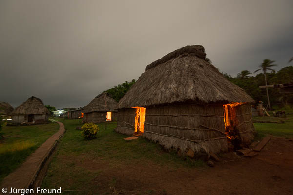 Night time shot of traditional Fijian bure or homes made with thatched roofs and natural material walls.