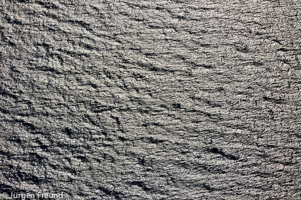 Aerial of a fishing boat in the middle of the sea catching fish with a pole and line.
